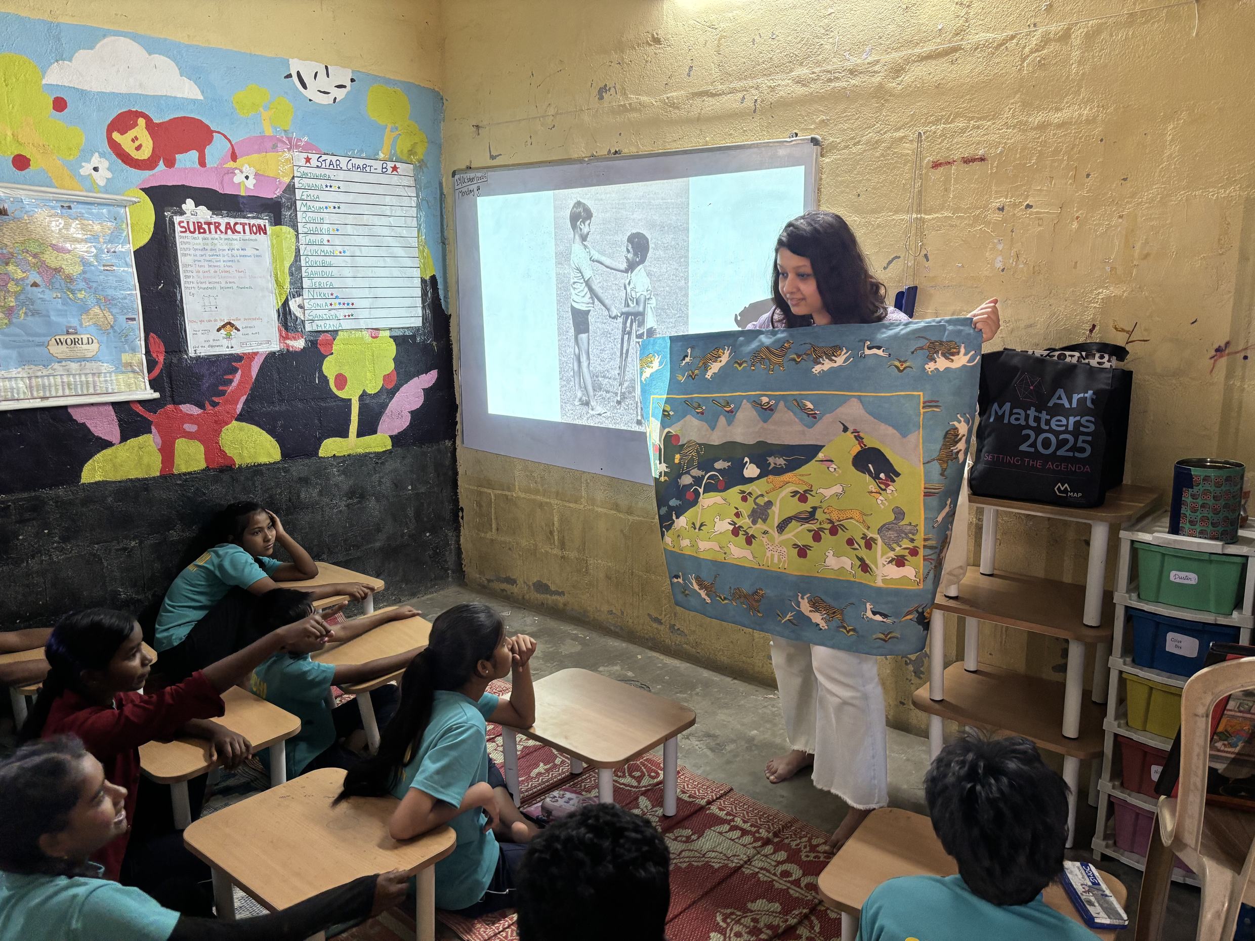 Facilitator conducting the close looking component of the module using the replica of Shikargah Dhurrie.